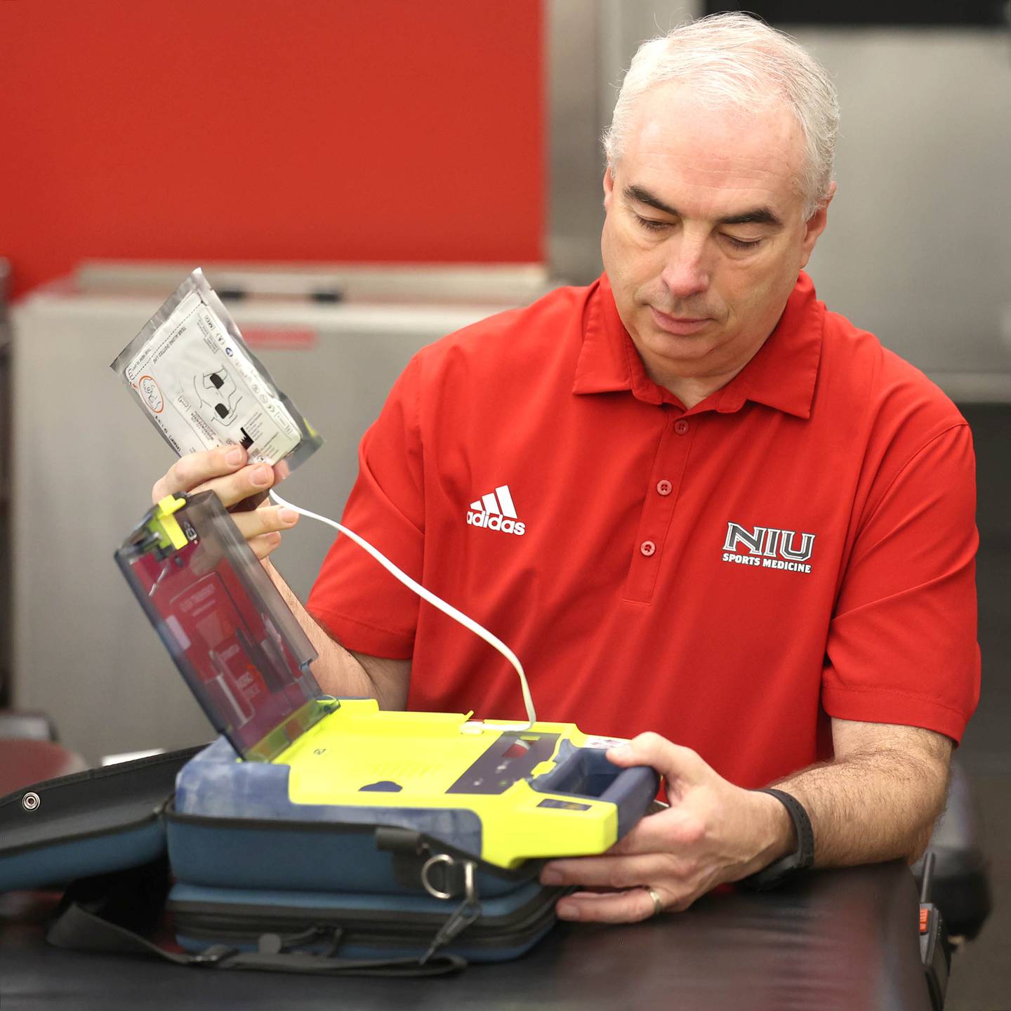 Phil Voorhis, Associate Athletic Director for Sports Medicine and Athletic Training at Northern Illinois University, pulls out the contents of an Automated External Defibrillator (AED) Tuesday, March 26, 2024, in the athletic training room in the Yordon Center at NIU in DeKalb.