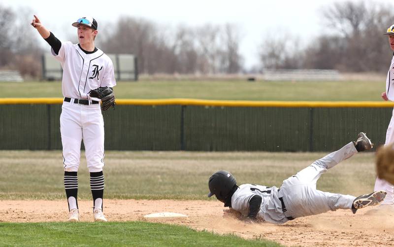 DeKalb's Ethan McCarter slides safely into second as Kaneland's Johnny Spallasso alerts teammates that a runner is trying to score during their game Friday, April 15, 2022, at Kaneland High School in Maple Park.