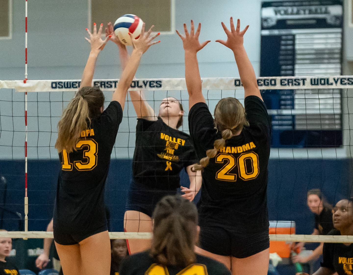 Oswego East's Megan Maier (center) goes up for a kill against Oswego’s Sidney Hamaker (13) and Kennedy Hugunin (20) during a volleyball match at Oswego East High School on Thursday, Sep 15, 2022.