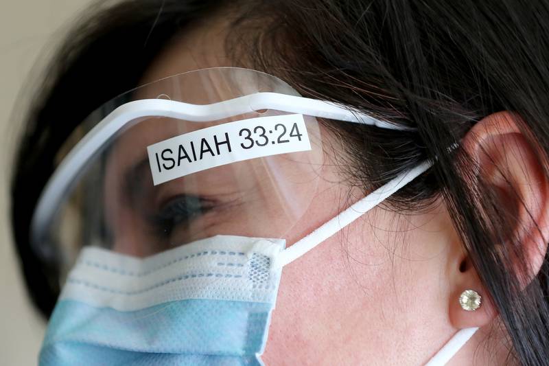 A bible passage reference to Isaiah 33:24 is displayed on the protective eyewear of interpreter Viviana Avila at Northwestern Medicine Huntley Campus on Thursday, March 4, 2021 in Huntley. The passage is special to Avila, which reads "And no resident will say: 'I am sick.'"