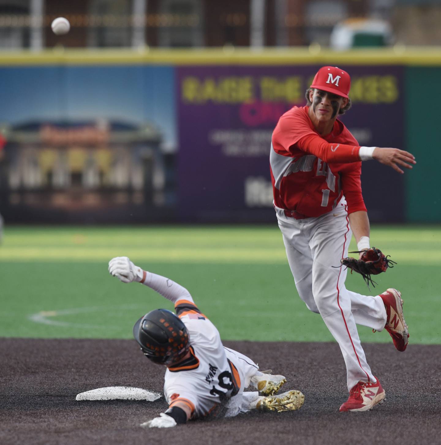 Mundelein shortstop Michael Farina throws to first to complete a double play as McHenry’s Eddie Synek slides during the Class 4A state semifinals Friday at Duvy Health and Care Field in Joliet.