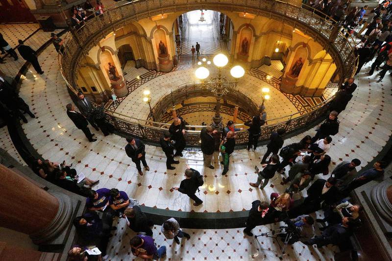 Students and lobbyist gather along the "Brass Rail" outside the Senate chambers to lobby their lawmakers against budget cuts affecting education spending at the state Capitol, Tuesday, Oct. 20, 2015, in Springfield, Ill.