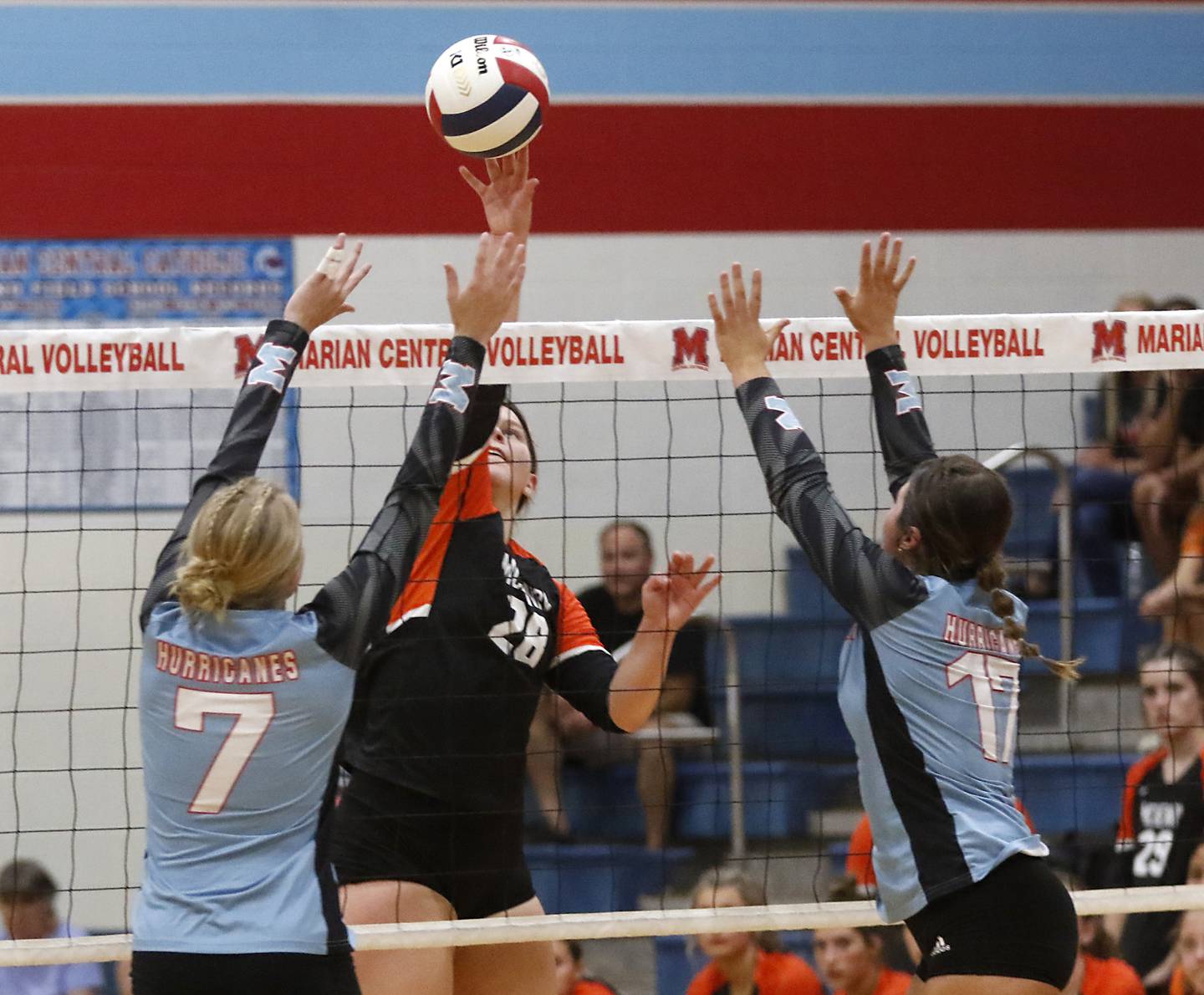 McHenry's Erin Nothdorf hits the ball between Marian Central's Jordan Orlos and Alex Rewiako during a nonconference volleyball match Monday, Aug. 28, 2023, at Marian Central Catholic High School.