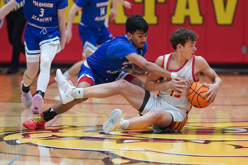 Batavia’s Dane Farrar (15) dives for a loose ball against Marmion's Ali Muhammed Tharwani (5) during a basketball game at Batavia High School on Wednesday, Nov. 27, 2024.
