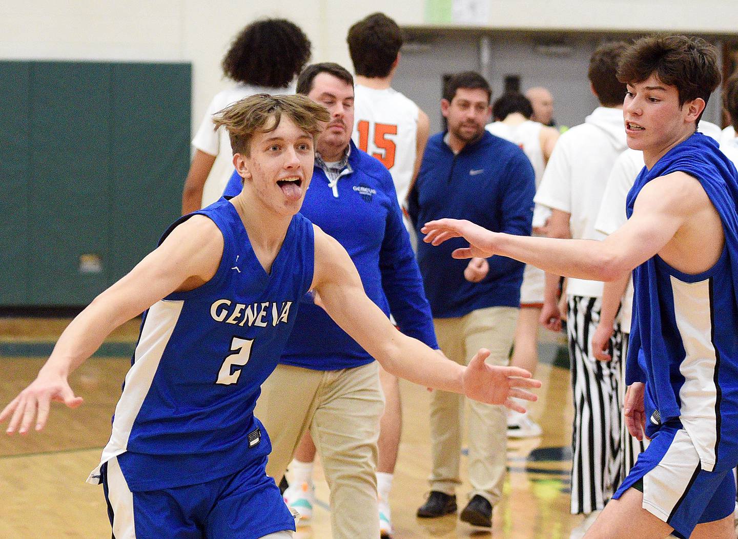 Geneva's Michael Lawrence races toward a group of fans who rushed the court following their win over Wheaton Warrenville South during the Class 4A Bartlett sectional semifinals Wednesday.