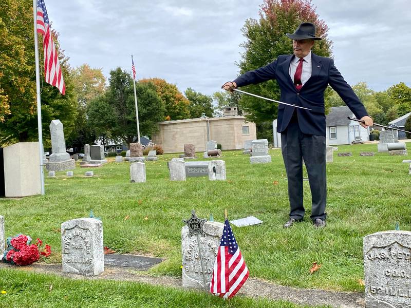 Lars Jacobson, member of the Sons of Union Veterans of the Civil War,  presents information on Martin Hare, a Sycamore Civil War veteran who lived from 1837 to 1911, a private corp. who served in the 9th Illinois Calvary. Jacobson displays a calvary saber likely used during combat in the war. Jacobson spoke at the DeKalb County History Center’s annual Etched in Stone Cemetery Walk at Elmwood Cemetery, 901 S. Cross St., Sycamore on Sunday, Oct. 8, 2023.