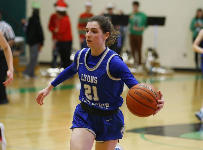 Lyons' Ally Cesarini (21) brings the ball up during the girls varsity basketball game between Lyons Township and York high schools on Friday, Dec. 16, 2022 in Elmhurst, IL.