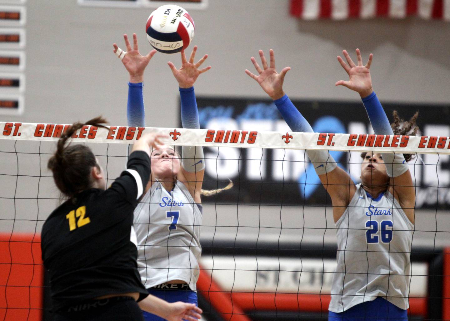 St. Charles North’s Mia McCall (left) and Sidney Wright attempt a block from St. Charles East’s Kaylee McInnis during a game at St. Charles East on Tuesday, Sept. 26, 2023.