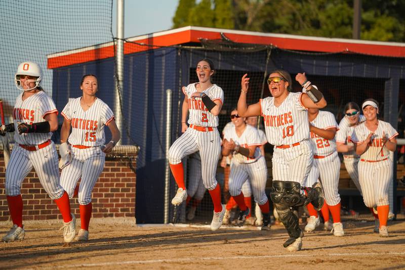 Oswego players leave the bench in celebration after a homer from Oswego’s Jaelynn Anthony (not pictured) against Minooka during a Southwest Prairie Conference softball game at Oswego High School on Wednesday, April 23, 2025.