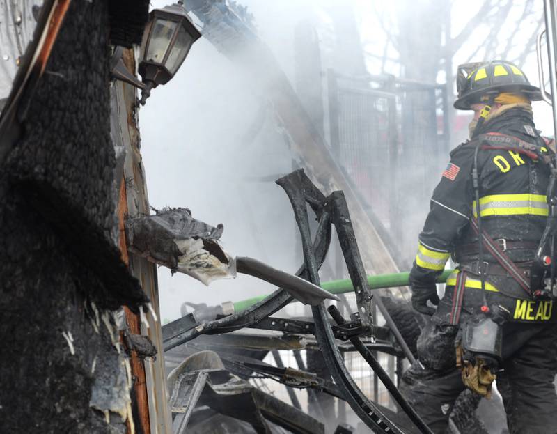 An Oregon firefighter watches as water is sprayed on a vehicle inside a detached garage fire at 7483 E. Husking Peg Road, Chana, on Friday, Feb. 14, 2025. Firefighters from several departments were called to the rural scene in frigid temperatures to extinguish the fire.