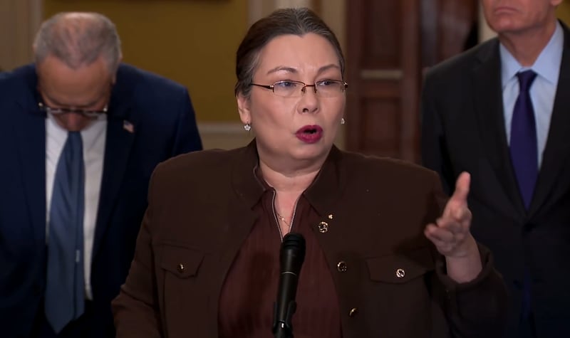 U.S. Sen. Tammy Duckworth, of Illinois, joined by fellow Democratic legislators, Senate Minority Leader Chuck Schumer of New York (left) and Mark Warner of Virginia, speaks at a news conference from Washington, D.C. on Tuesday, Jan. 6, 2026, against President Donald Trump's actions ordering the U.S. military to strike Venezuela and depose Nicolas Maduro without congressional approval. (Screengrab of live televised press conference)