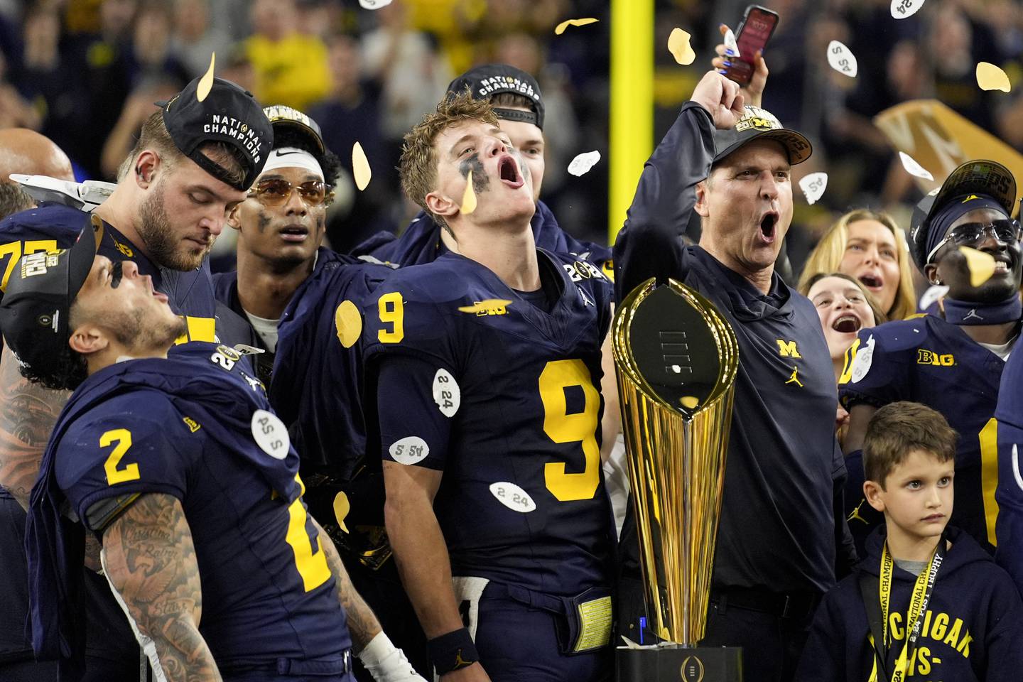 Michigan head coach Jim Harbaugh and quarterback J.J. McCarthy celebrate with the trophy after their win against Washington in the national championship game in January in Houston.