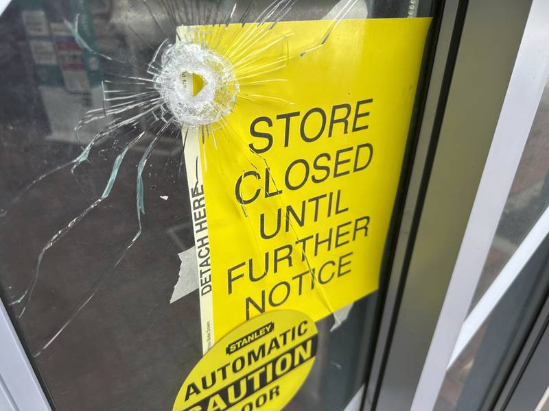 A bullet hole is visible in the door of a CVS pharmacy on Saturday, August 9, 2025,  near where police say a man was shooting at the headquarters of the U.S. Centers for Disease Control and Prevention in Atlanta. (AP Photo/Jeff Amy)