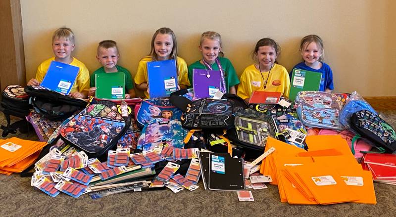 Dakota, Tucker, Oakley, Navie, Noel and Elodie show off the school supplies the congregation at Trinity Church United Methodist in Yorkville donated to the Kendall County Community Food Pantry.