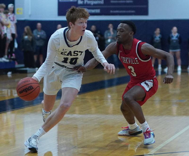 Oswego East's Noah Mason (10) dribbles the ball against Yorkville's Dayvion Johnson (3) during a basketball game at Oswego East High School on Friday, Dec 8, 2023.