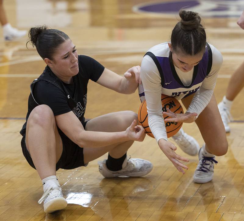 Dixon’s Kiley Gaither and Kaneland’s Kalie Brown fight for a loose ball Wednesday, Dec. 10, 2025.