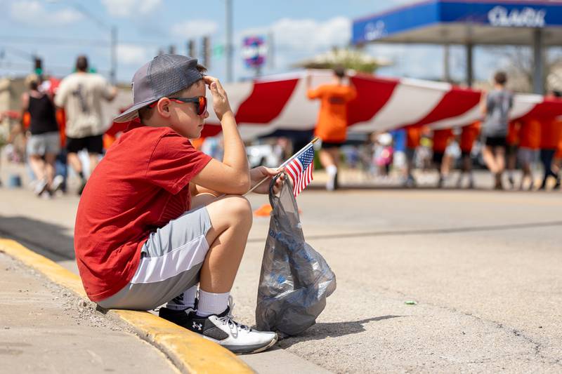 Ryker Casey sits on curb as parade passes through on Sunday, Aug 31, 2025 at the Labor Day parade on Main Street in Streator.