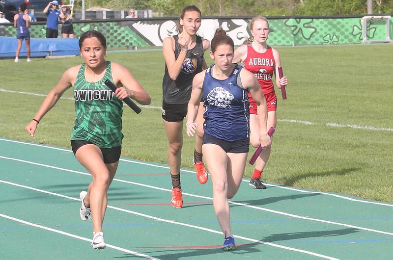 (From left) Dwight's Bridget Zavala, Chicago Christian's Jay Rivera, Lisle's Fausta Grigonis and Aurora Christian's Brieann Martinez compete in the 4x100 relay during the Class 1A Sectional track meet on Thursday, May 15, 2025 at Seneca High School.