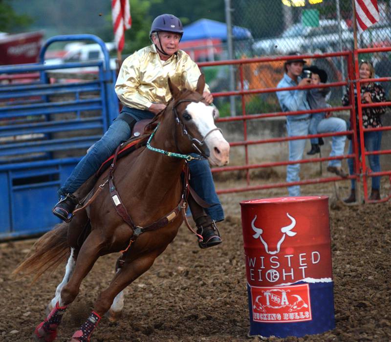 Ellen Inman, 76, of Davis Junction, rounds a barrel in one of the barrel racing divisions during the T & A Bucking Bulls Rodeo at the Ogle County Fair on Friday, Aug. 1, 2025 in Oregon.