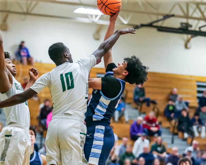 Nazareth's Rasim Johnson (12) puts up a shot over Glenbard West's Josh Abushanab (10) during their Jack Tosh Holiday Classic basketball tournament game between Nazareth vs Glenbard West. Thursday Dec 26, 2024 in Elmhurst.