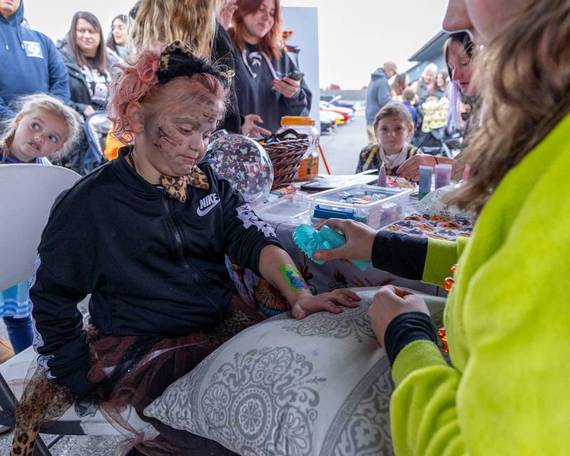 Raelynn Lee gets arm paint dried at the trunk or treat event on Saturday, October 25, 2025 at Illinois Valley Auto Group in Peru.