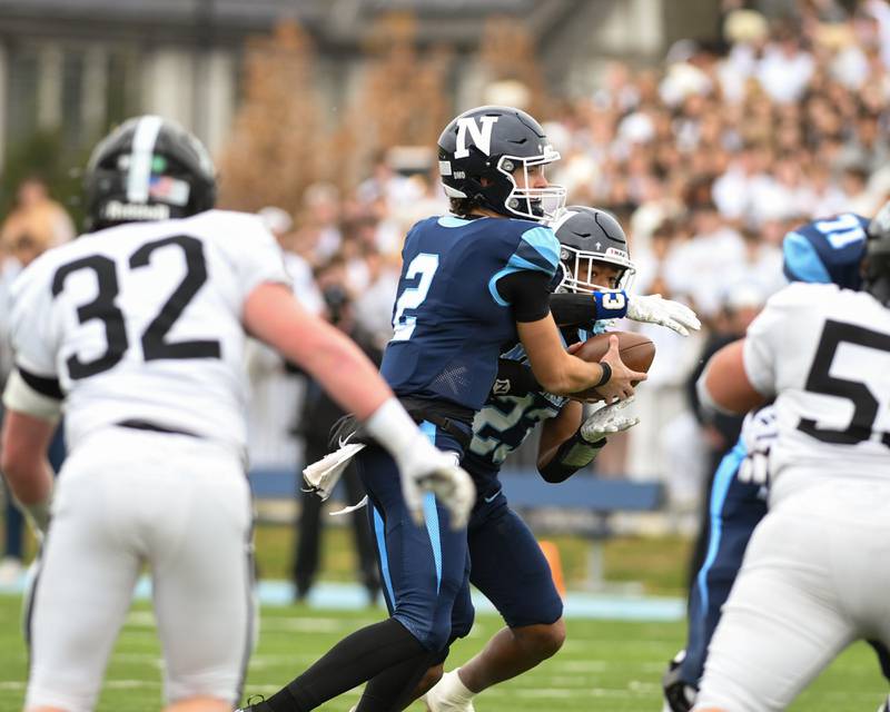 Nazareth Academy's Jackson Failla (2) hands the ball off to teammate Justin Watson (23) during the 6A semifinals game while taking on Fenwick on Saturday Nov. 22, 2025, held at Nazareth Academy High School in La Grange Park.
