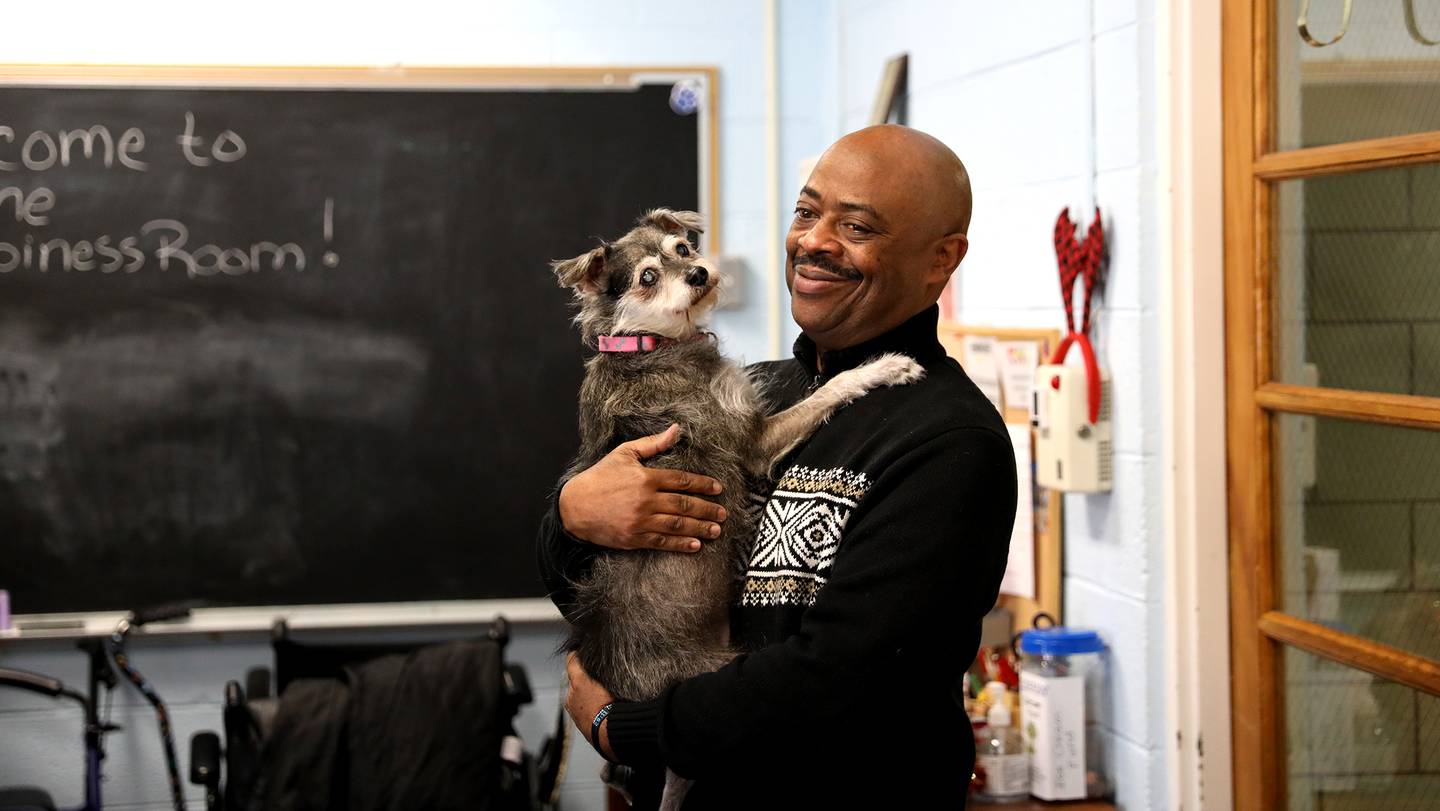 President and CEO Michael Cobb holds his dog, Amavi, at the Elderday Center in Batavia. The center, which offers therapeutic care for seniors will celebrate 35 years of service this year.