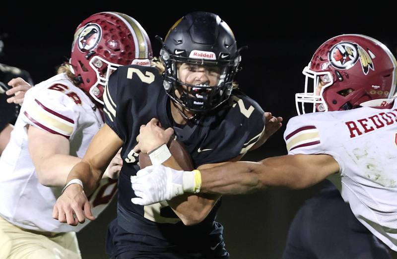 Sycamore's Elijah Meier splits two Morris defenders during their game Friday, Oct. 21, 2022, at Sycamore High School.