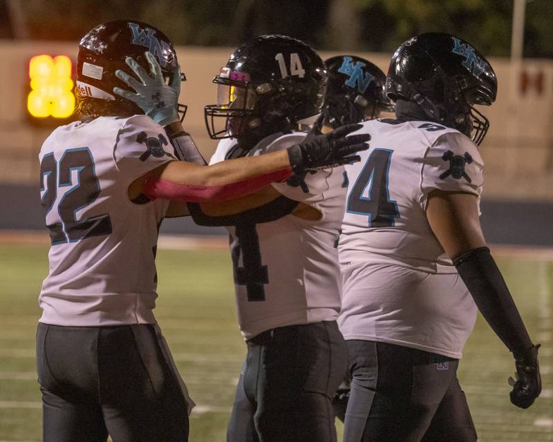 Woodstock North's Dillon Morrison (middle) celebrates with teammate Parker Halihan's (left) after scoring a touchdown against L-P during the game at Howard Fellows Stadium on Friday, Sept. 8, 2023.