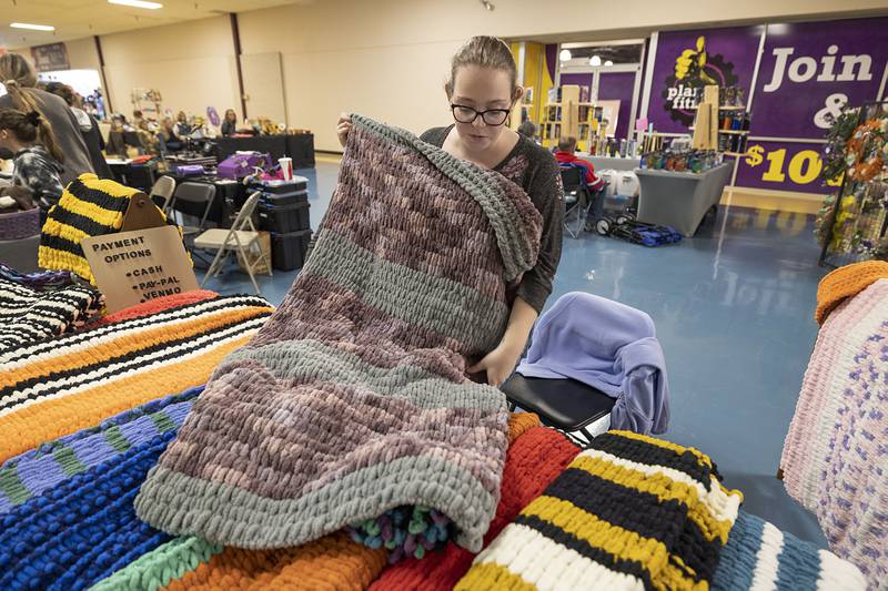 Jessica Conway shows off her favorite blanket Saturday, March 4, 2023 at her booth at the arts and crafts show at the Northland Mall. Conway hand makes the items for her business Jessica’s Blankets and Throws.