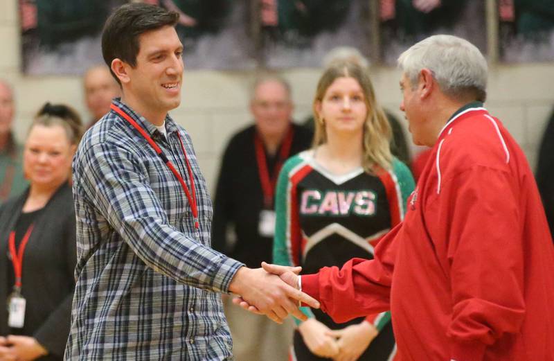 Brandon Swindler L-P class of 2010, shakes L-P board member Greg Sarver's hand while being introduced at halftime during the La Salle-Peru Township High School Hall of Honor ceremony on Friday, Feb. 7, 2025 in Sellett Gymnasium at L-P High School.