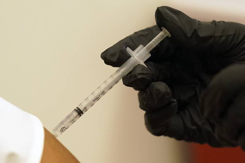 A person is injected with her second dose of the Pfizer COVID-19 vaccine at a Dallas County Health and Human Services vaccination site in Dallas, Thursday, Aug. 26, 2021.  Federal health regulators on Friday, Feb. 11, 2022 delayed next week's public meeting to review Pfizer’s COVID-19 vaccine for children under 5, saying they want to see more data. (AP Photo/LM Otero, File)