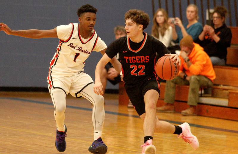 Crystal Lake Central’s Johnny Geisser, right, moves the ball past Huntley’s Bryce Walker during tournament basketball action at Johnsburg High School Monday evening.