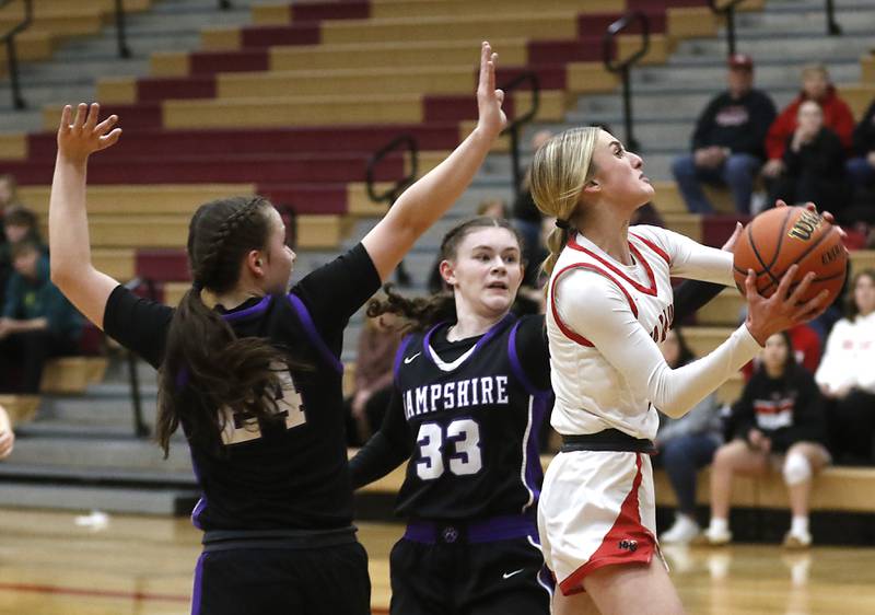Huntley's Anna Campanelli splits the defense of Hampshire's Whitney Thompson and Ashley Herzing as she drives to the basket during a Fox Valley Conference girls basketball game Monday, Jan. 30, 2023, at Huntley High School.