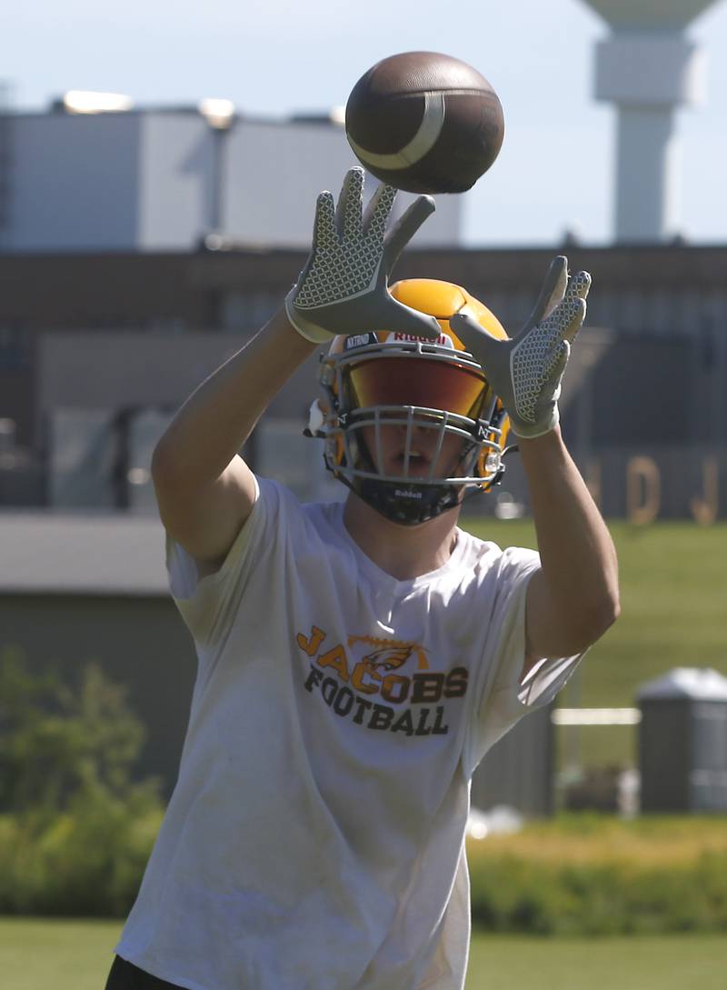 Grant Stec catches the ball during football practice Monday, June 20, 2022, at Jacobs High School in Algonquin.