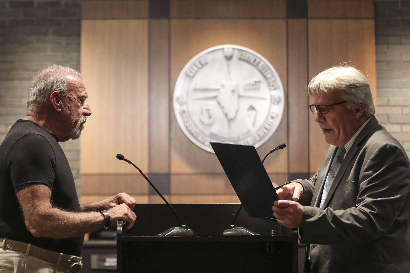 Councilman Larry Hug (right) reads a proclamation honoring Herb Lande (left) as he leaves the city council on Monday, May 3, 2021, at Joliet City Hall in Joliet, Ill. After a tight race, three new City Councilman were sworn in at a special meeting on Tuesday.