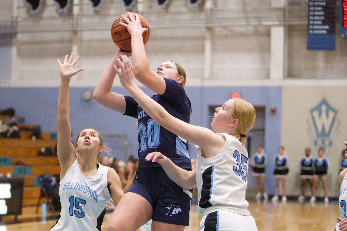 Downer's Grove South's Megan Ganschow drives to the basket against Willowbrook's Sarah Stout (15) and Halie Ahrens (35) on Friday, Feb.3,2023 in Villa Park.