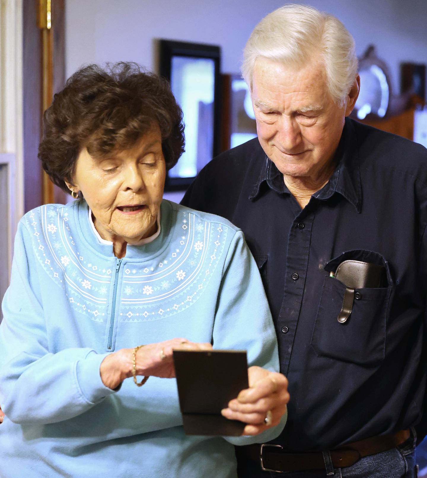 Morry and Joan Drury look at a photo from their wedding day in 1952 Thursday, Feb. 9, 2023, at their home in DeKalb. The couple celebrated their 70th wedding anniversary in Sept. of last year.