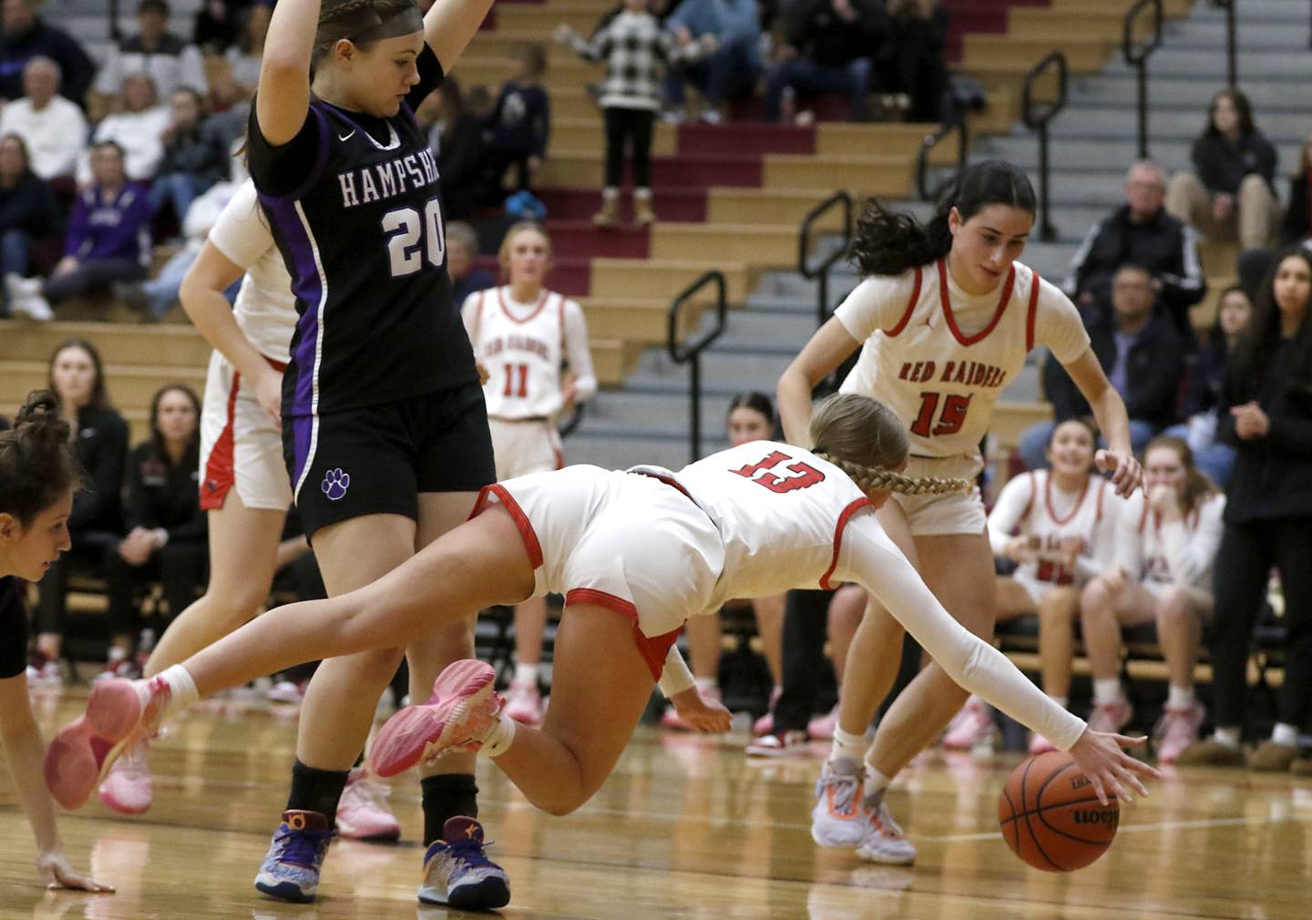 Huntley's Morgan McCaughn dives as she tries to save the ball from going out of bounds in front of Hampshire's Chloe Van Horn and Huntley's Jessie Ozzauto during a Fox Valley Conference girls basketball game Monday, Jan. 30, 2023, at Huntley High School.