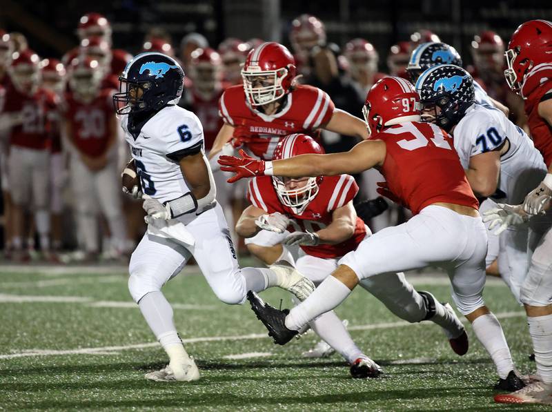 Downers Grove South's Deon Davis (6) moves upfield past a host of Naperville Central defenders Friday October 27, 2023 in Naperville.