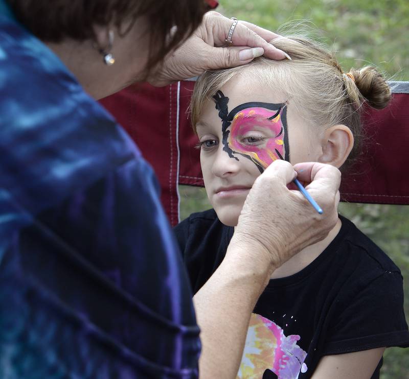 Penny Vickers has a colorful design painted on her face Tuesday, Aug. 8, 2023, during Unlimited Fun Day at City Park in Streator. The event was sponsored by Streator Unlimited.