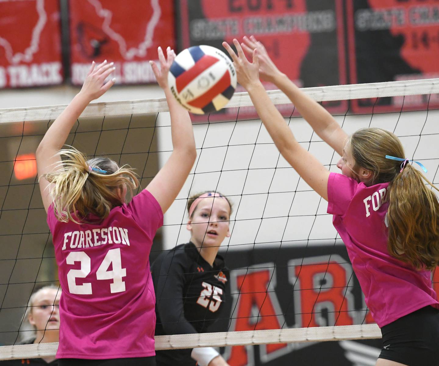 Milledgeville's Lilianna Smith spikes between two Forreston blockerss during the Volley for the Cure game on Tuesday, Sept. 27.