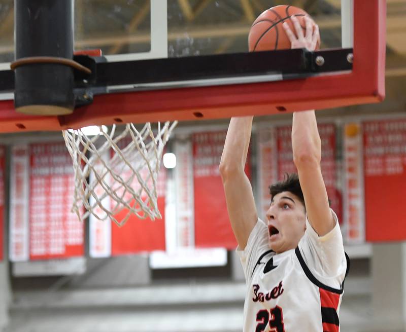 Benet's Niko Abusara (23) slam dunks the ball for the first score of the game during a "When Sides Collide" invitational game against Kenwood on Jan. 21, 2023 at Benet Academy in Lisle.