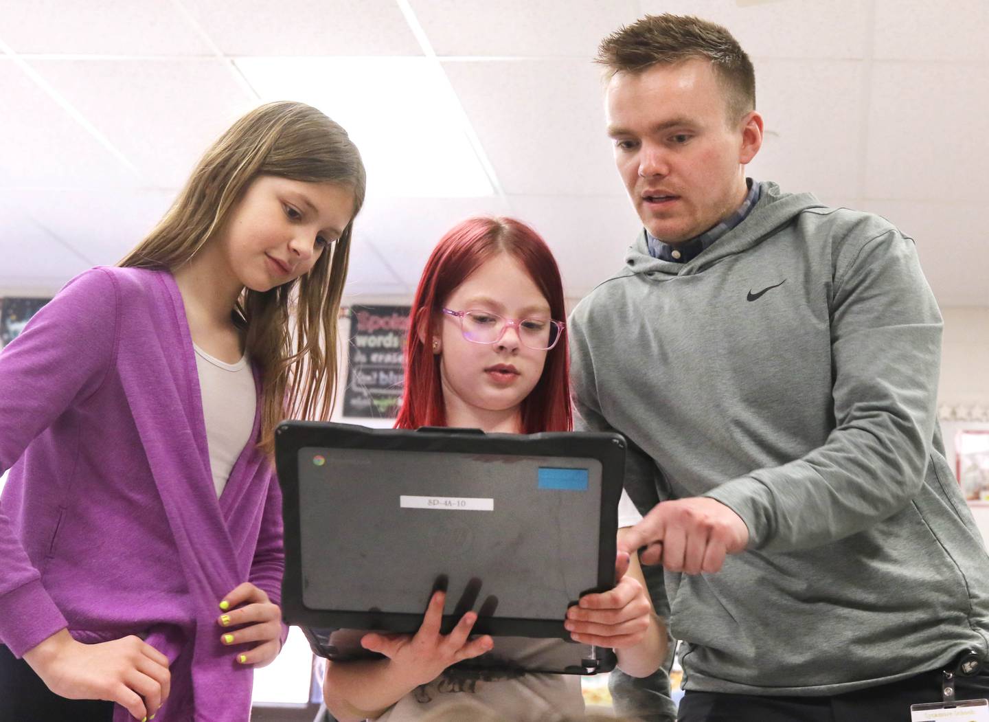 Jacob Winters, fourth grade teacher at South Prairie Elementary School, works with students Adalynn Snider (left) and Amelia Mastny Wednesday, April 6, 2023, at the school in Sycamore.