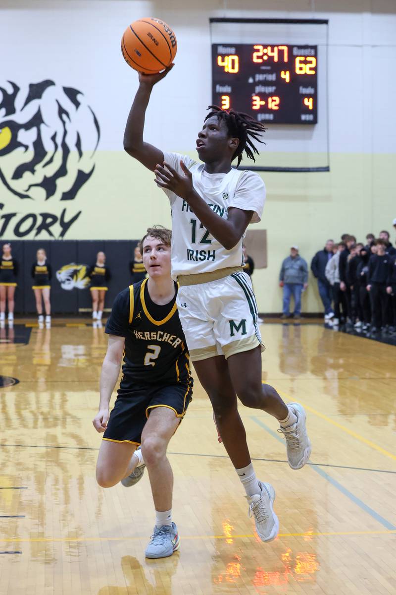 Bishop McNamara's Corey Hathaway shoots past Herscher's Austin Buckley during Bishop McNamara's 71-42 victory in the IHSA Class 2A Herscher Regional semifinal on Wednesday, Feb. 25, 2026.