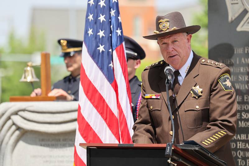 Kankakee County Sheriff Mike Downey reads the roll call of fallen officers as Kankakee Police Chief Chris Kidwell rings the bell for each name during the annual Law Enforcement Officers Memorial Ceremony honoring Kankakee County officers, held on the lawn of the Kankakee County Courthouse on Thursday, May 15, 2025.