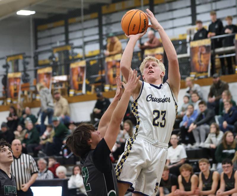 Marquette's Luke McCullough lets go of a jump shot over Midland's Ben Walker during the Tri-County Conference Tournament on Monday, Jan. 26, 2026 at Putnam County High School