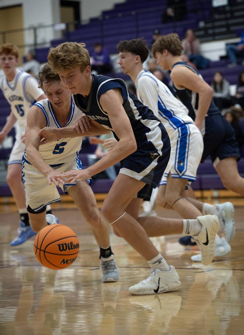 IC Catholic's Alex Simkowski, right, controls the ball as Peotone's Nate Wehrmann, left, attempts a steal in the Thanksgiving tournament at Manteno High School on Monday, November 24, 2025.