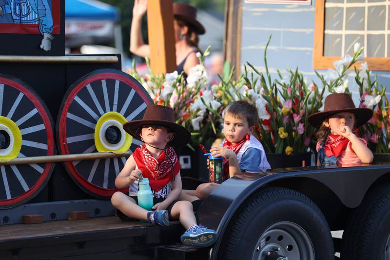 Young parade participants observe the crowd from the First Baptist Church float during the 87th Momence Gladiolus Festival Main Street Parade on Friday, Aug. 8, 2025.