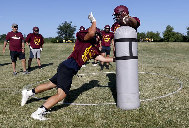 Richmond-Burton’s Nate Komar hits the football tries to cause a fumble during a drill  during summer football practice Thursday, July 14, 2022, at Richmond-Burton High School in Richmond.